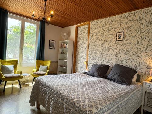 1 Schlafzimmer mit einem Bett und 2 Stühlen in der Unterkunft En ville avec un air de campagne in Arles