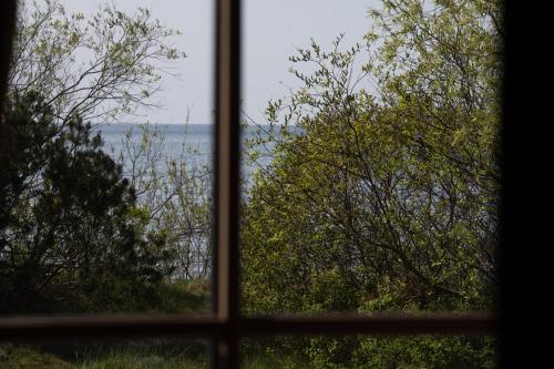 a window with a view of the water seen through it at Amber VIP Hotel in Pāvilosta