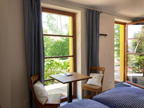 Cette chambre comprend un lit, une table et une fenêtre. dans l'établissement Teichland Linum Apartments, à Fehrbellin