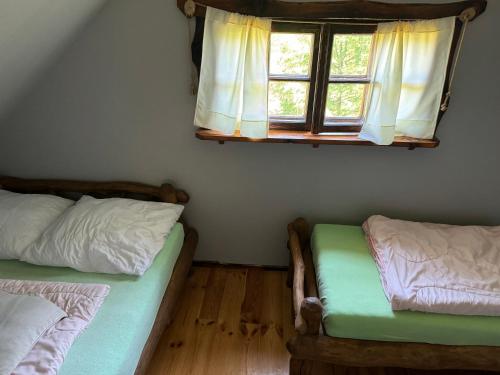 - une chambre avec 2 lits et une fenêtre dans l'établissement Domek nad Stawem, à Giżycko