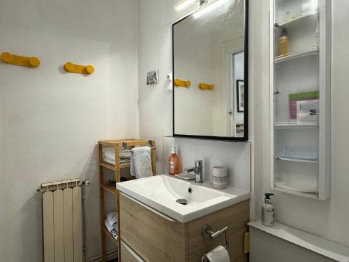 un bagno con lavandino e specchio di En ville avec un air de campagne a Arles