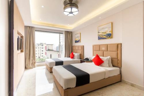 um quarto de hotel com duas camas e uma janela em Townhouse Krish Residency Near Newtown Bus Stand em Calcutá