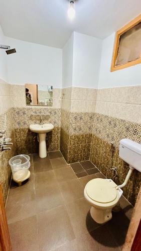 a bathroom with a toilet and a sink at Hotel Ocean & Meadows Open Terrace ! Mall Road Hotel ! in Manāli
