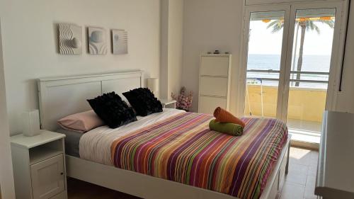 a bedroom with a bed with a view of the ocean at Apartamento Primera Linea de Mar, Cunit in Cunit