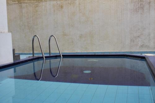 a swimming pool with two metal rails in the water at Natures Bliss Holidays in Ja-Ela