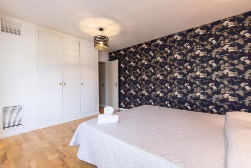 a bedroom with a bed with a black and white wall at Martorell Planet Costa Dorada in Cambrils
