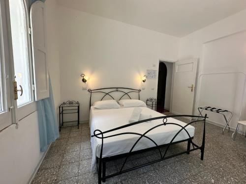 a white bedroom with a bed and two chairs at Rada Azzurra in Amalfi