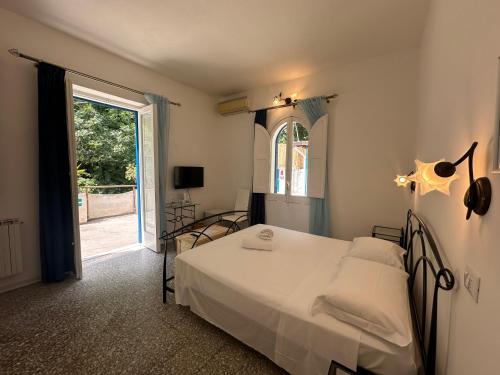 a bedroom with a white bed and a window at Rada Azzurra in Amalfi