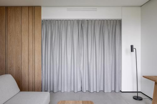 a bedroom with a bed and a window with white curtains at Cherot in Krymno