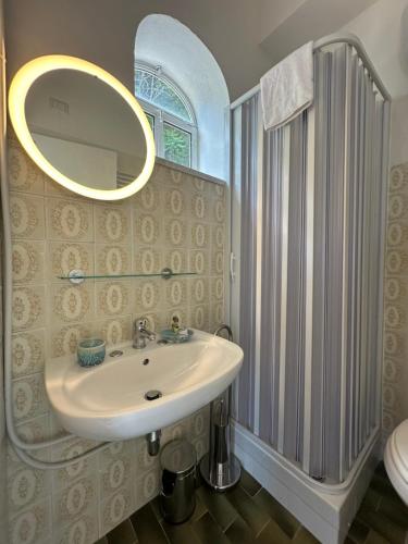 a bathroom with a sink and a shower and a mirror at Rada Azzurra in Amalfi