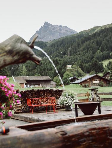 a red bench sitting on a deck with a fountain at Heimspitze - Alpenhotel & Wirtshaus in Gargellen