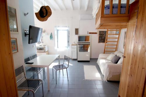 a kitchen and living room with a couch and a table at Lily's Studio in Astypalaia Town