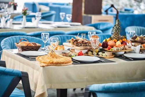 een tafel met eten en blauwe stoelen bij Ulug`bek Grand Hotel in Samarkand