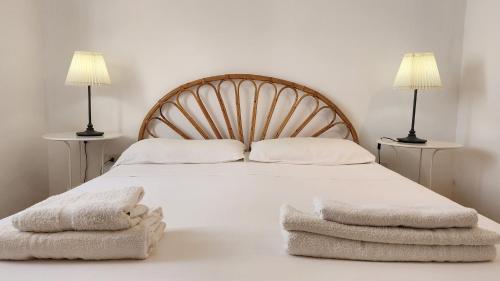 a bedroom with a bed with two lamps and two towels at Villa Mediterraneo in Fontane Bianche