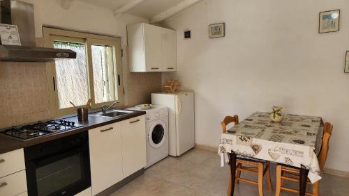 a kitchen with a stove top oven next to a table at Villa Mediterraneo in Fontane Bianche