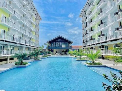 a swimming pool in the middle of two apartment buildings at 119 Amani Grand Mactan Resort in Mactan