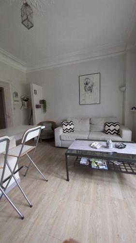 un salon avec un canapé, une table et des chaises dans l'établissement Appartement Colmar Centre Le 4, à Colmar