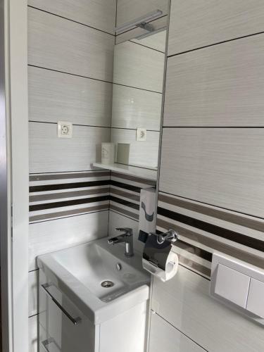 a white bathroom with a sink and a mirror at Tisno Resort in Tisno