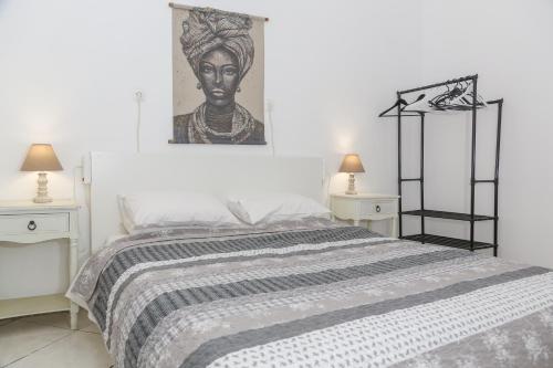 um quarto com uma cama com um retrato de uma mulher em Stefano's country house 2 em Chania Town
