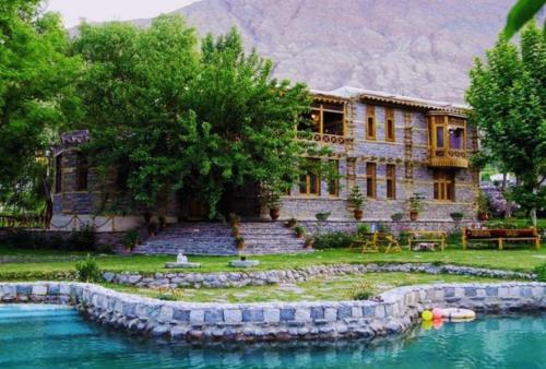 a house with a lake in front of it at Riverdale in Gilgit