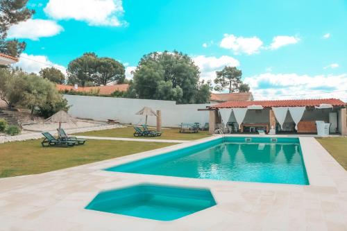 a swimming pool in a yard with a house at Charme Lusitano Countryside Experiences in Inguias