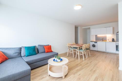 un salon avec un canapé bleu et une table dans l'établissement M50 Marquer Jolie chambre, à Annemasse