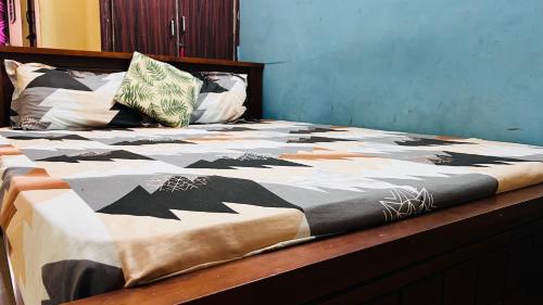 Una cama con un edredón blanco y negro. en OYO 81239 Shri Vinayaka Inn Rooms, en Tiruchchirāppalli