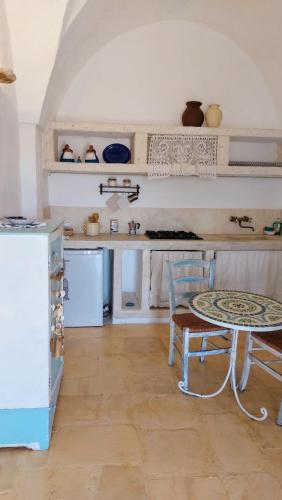 a kitchen with a table and a chair in a room at Masseria Verbena Agriturismo in Monopoli