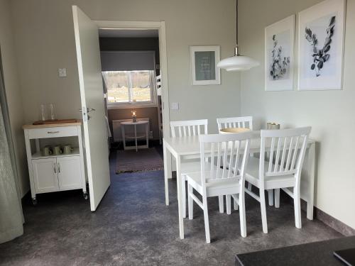 a dining room with a white table and chairs at Halmstad Golfarena stugor in Halmstad