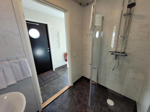 a bathroom with a shower and a glass shower backdoor at Halmstad Golfarena stugor in Halmstad
