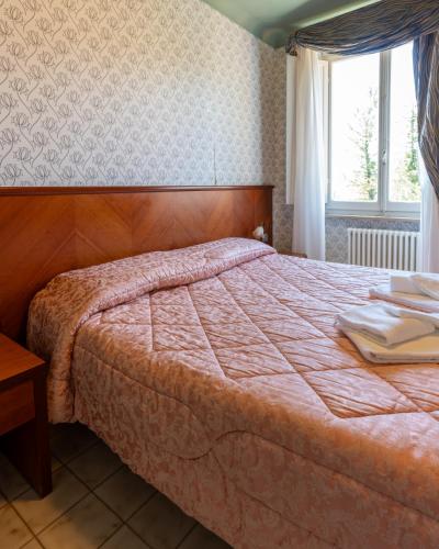 a bedroom with a bed and a window at Hotel Terme in Sarnano