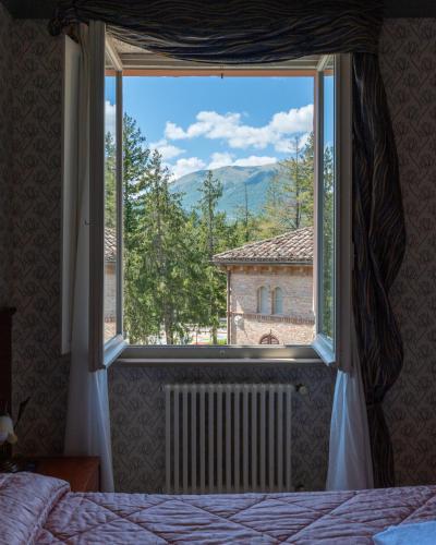 a bedroom with a large window with a view at Hotel Terme in Sarnano