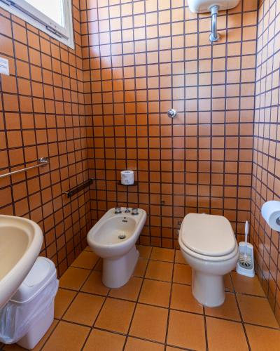 a bathroom with a toilet and a bidet and a sink at Hotel Terme in Sarnano