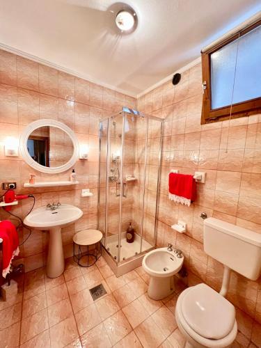 a bathroom with a shower and a toilet and a sink at Ciasa AGB in Moena