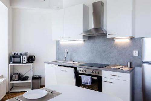 a kitchen with white cabinets and a stove top oven at Studio K2 in Brno