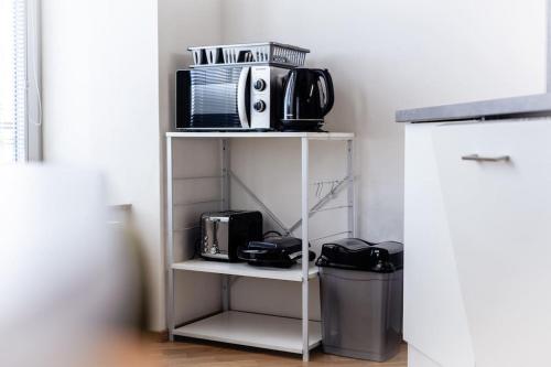 a white shelf with a microwave and a toaster at Studio K2 in Brno