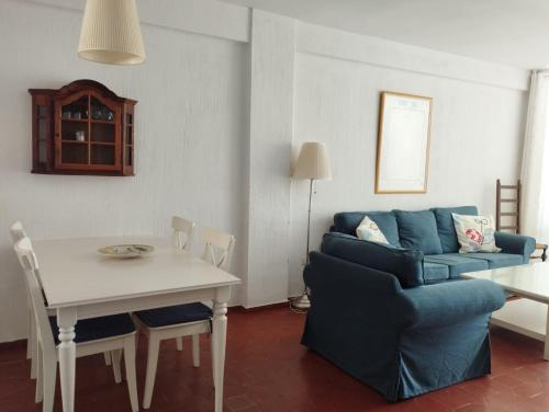 een woonkamer met een blauwe bank en een tafel bij VERDEMAR 16 MENYBER in Nerja