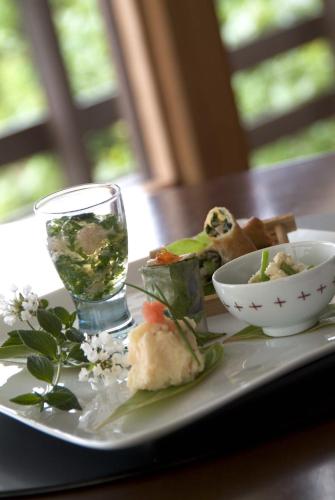 a plate of food and a glass of water on a table at Mashio Hotel & Resort in Oshima