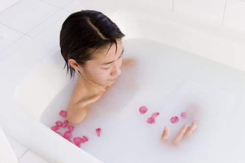 Mashio Hotel & Resort في Oshima: امرأة في حوض استحمام بقلوب وردية