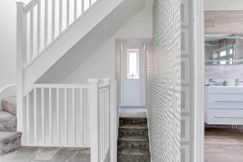een witte trap in een huis met witte muren bij The Burlington at Romford in Romford