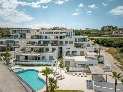 una vista aérea de un gran edificio de apartamentos blanco con piscina en AmphiMatrion Luxury Apartments en Kalyves