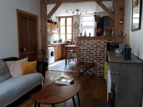 un salon et une cuisine avec un canapé et une table dans l'établissement Maison avec patio centre ville quartier calme, à Arbois