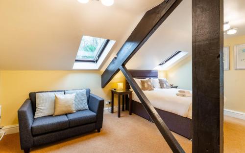 a attic bedroom with a bed and a chair at Mill Top in Ambleside