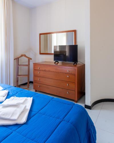 a bedroom with a bed and a dresser with a mirror at Hotel Terme in Sarnano