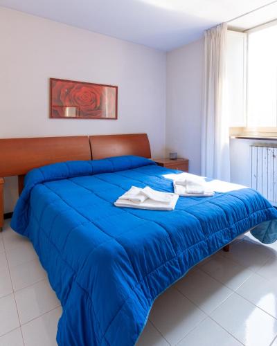 a blue bed with two towels on top of it at Hotel Terme in Sarnano
