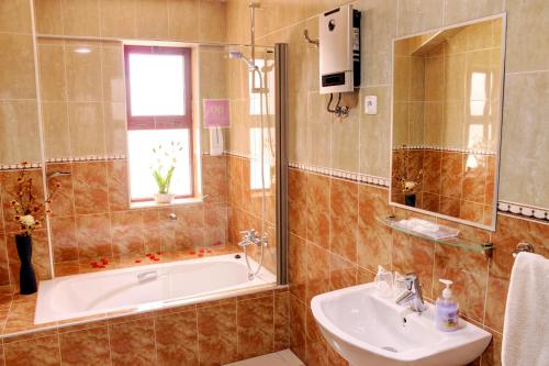 uma casa de banho com uma banheira e um lavatório em Hotel LIVVO Don Paco em Mindelo