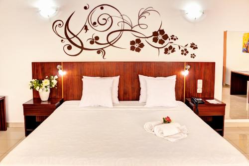 a bedroom with a large bed with a wooden headboard at Hotel LIVVO Don Paco in Mindelo