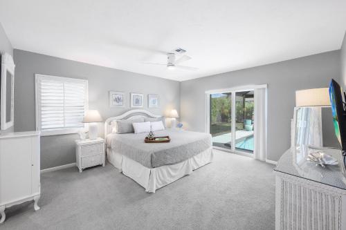 Un dormitorio con una cama y un televisor. en Nautical home with pool, grill and steps to shops, en Marco Island