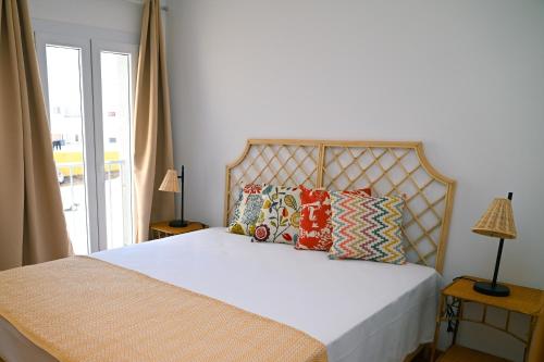 una camera da letto con un letto con cuscini e una finestra di TURISALENTEJO - ATIVIDADES TURÍSTICAS, LDA a Redondo