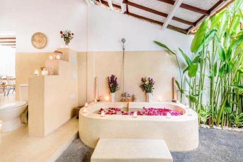 ein Badezimmer mit einer Badewanne mit Blumen. in der Unterkunft Villa Berlin - Private 6 BDR Villa in Seminyak with Pool and Garden in Seminyak